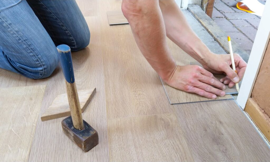 Persoon legt vloer tijdens verbouwing in opgeruimde ruimte na huis opruimen voor verbouwing