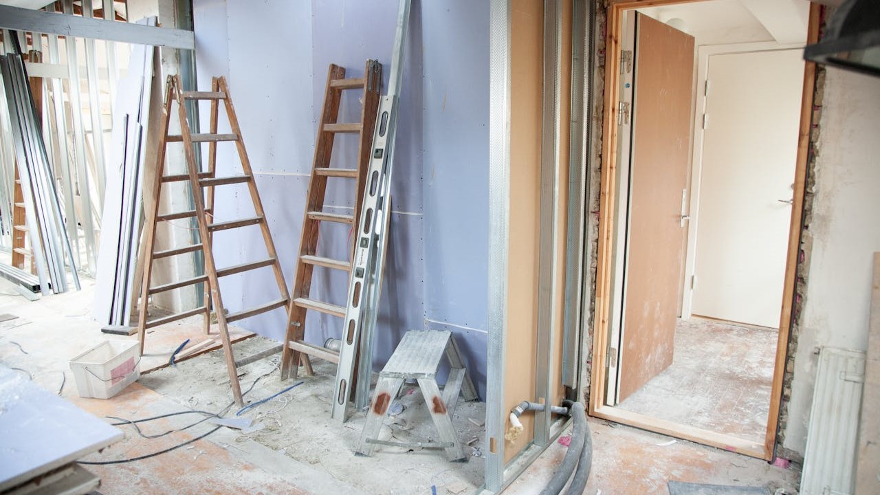 Binnenruimte in verbouwing met ladders en bouwmaterialen na het huis opruimen voor verbouwing